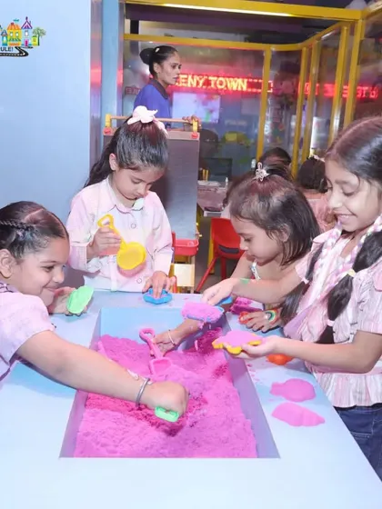 A group of friends enjoying our sensory play station with kinetic sand during a birthday party. It's a great activity for creative and tactile fun.