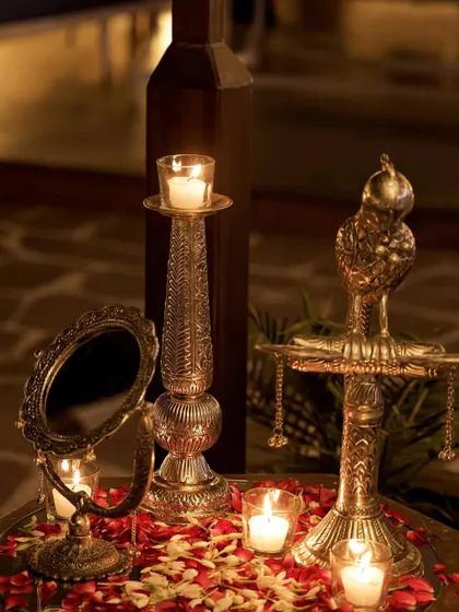 Traditional brass props, including a vintage mirror and sword, add an authentic, royal touch to the decor.
