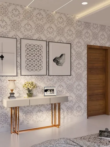 This console table area in a Yelahanka project uses patterned wallpaper and minimalist art to create an elegant corner. The rose gold legs of the table add a touch of modern luxury.