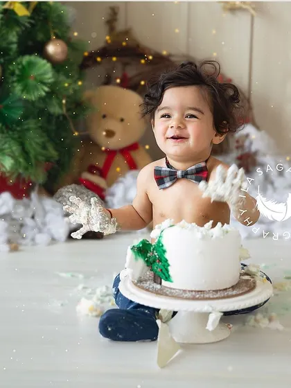 The aftermath of a festive Christmas cake smash. His happy, messy hands and big smile say it all.