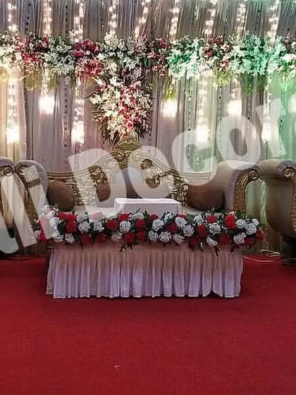 This is a classic reception stage setup with a red carpet, perfect for making a grand statement. The rental includes a full set of traditional golden furniture and a backdrop of drapes and floral arrangements.