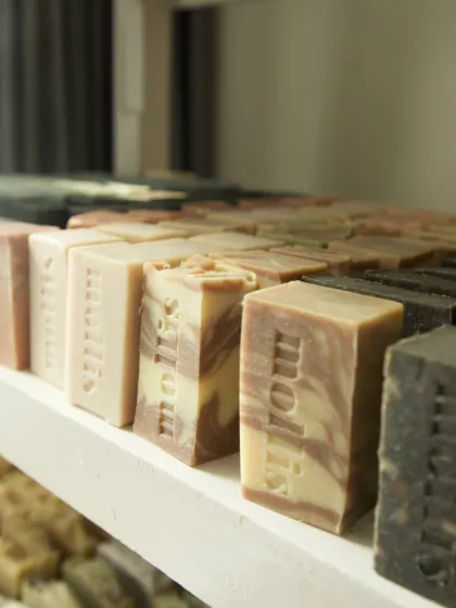 A close-up of the soaps on the curing rack, showing the hand-stamped logo on each bar.