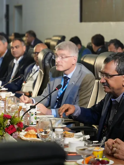 A table of international delegates focused on a presentation during a working lunch. Our service is designed to support the objectives of your corporate event, not distract from them.