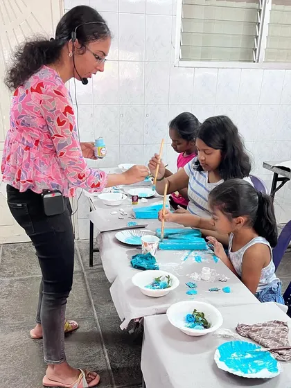 I love hosting art parties at my cozy home studio! Here I am guiding a group of 25 kids through a fun mixed-media project.