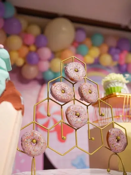 A close-up of the donut wall, a fun and tasty feature of the Candyland party. The giant cupcake props add to the larger-than-life sweet-shop feel.