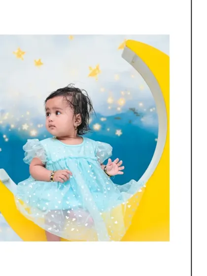 A vertical portrait from a 'Moon & Stars' shoot, perfect for framing. The composition highlights the baby's sweet expression and the magical theme.