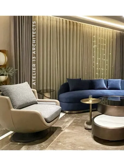 Designed for a family in Shanti Niketan, this lounge combines a bold curved blue velvet sofa with a sleek nesting table and a beige swivel armchair. The composition creates a perfect blend of warmth and contemporary sophistication.
