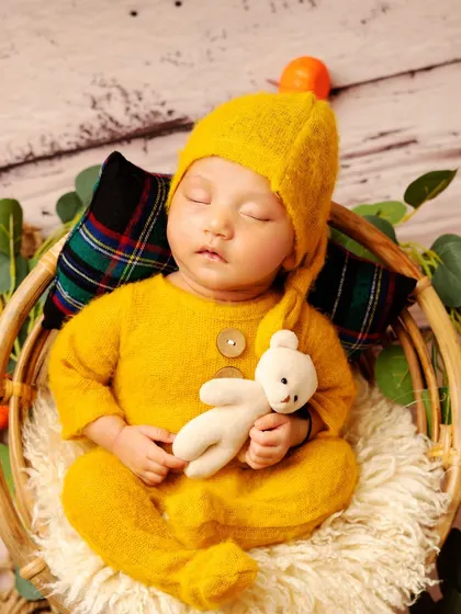 Cuddling a tiny teddy bear adds an extra layer of sweetness. I have a collection of soft, safe toys for babies to hold during their session.