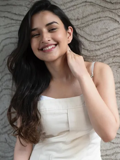 A bright and happy shot featuring a minimal makeup look with soft curls, perfect for a youthful and fresh aesthetic.