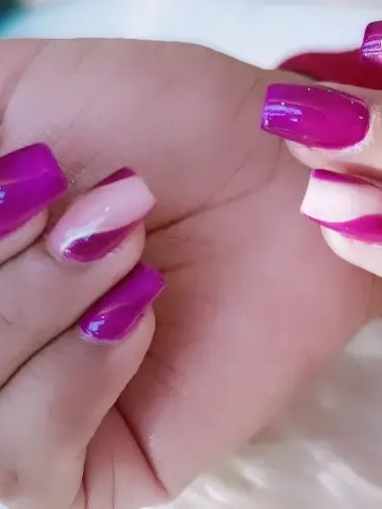 A bold graphic design with a mix of solid purple and sheer accent nails with abstract purple shapes.