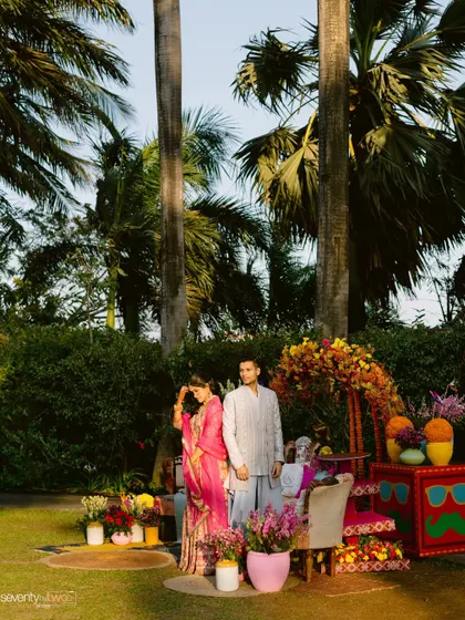 A beautiful shot of the couple at their colorful Mehendi ceremony, surrounded by vibrant decor and lush greenery.