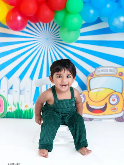 A bright and happy smile from this little boy. The colorful, cartoonish background adds a playful and fun element to his birthday portrait.