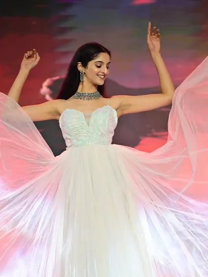 A dynamic shot on the runway, with the gown in full flight. The makeup is designed to keep the focus on her face, ensuring she shines on stage.