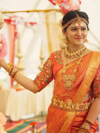 A candid moment from a shoot, featuring our complete Muhurtham jewellery set. The traditional headband adds an authentic touch to the bridal look.
