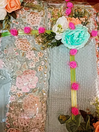 A beautiful light green suit with heavy embroidery, decorated with pink and mint green flowers. The color combination is soft and very elegant.