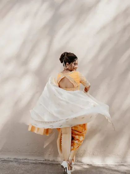 A joyful twirl showing the beautiful flow and movement of the Nauvari saree and shela, proving that traditional wear can be fun and dynamic.