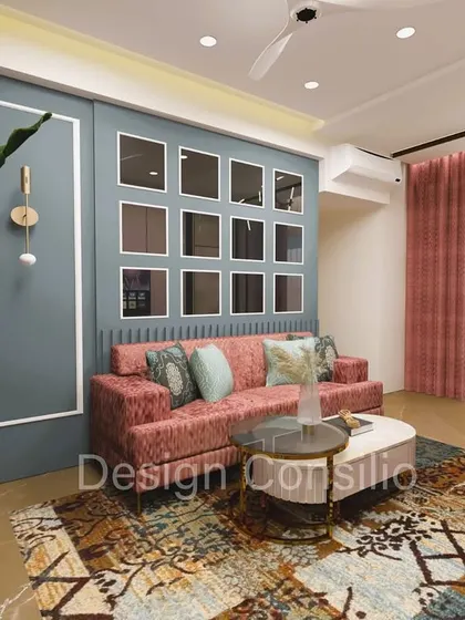 A living room with a bold color choice. The dusty pink sofa is set against a cool blue accent wall with decorative mirror panels, creating a vibrant and playful yet sophisticated space.