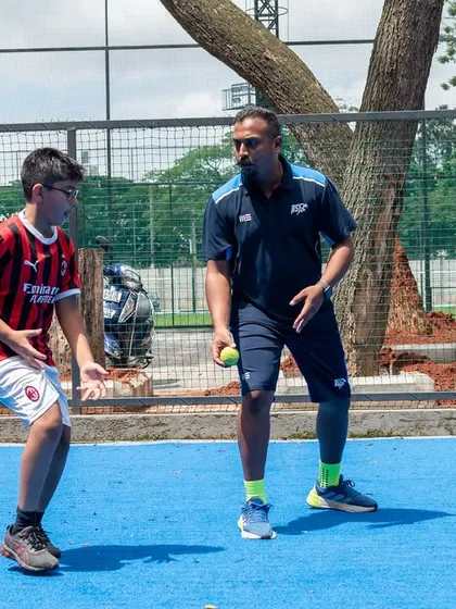 Coaching is about connection and clear instruction. Here, I am working with two young athletes on a reaction drill using tennis balls. This exercise improves hand-eye coordination, cognitive processing, and athletic stance, all critical skills for any sport.