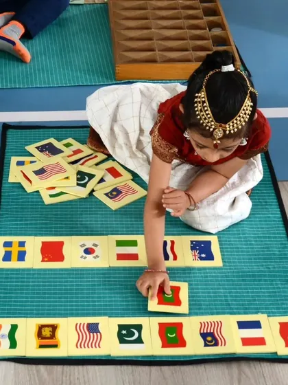 A child works with a geography puzzle, an example of how we teach in a holistic and experiential manner.