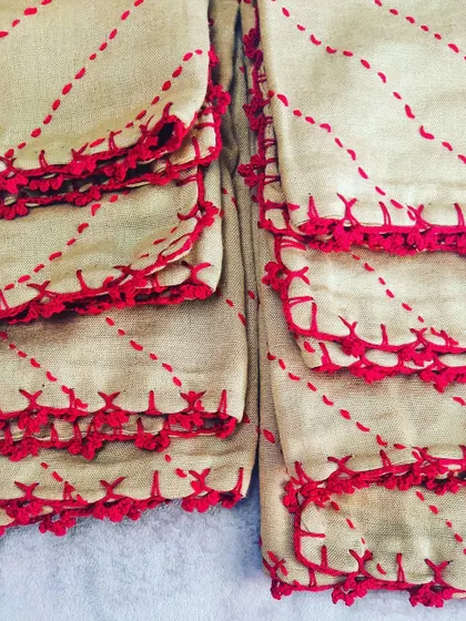 An example of our custom lacework. We added this red crochet edging and running stitch detail to a set of plain cushion covers, giving them a completely new and personalized look.