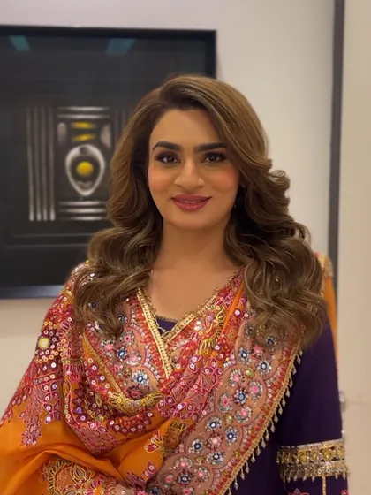 A happy client ready for her Diwali celebration, with her hair styled in glamorous, festive waves.