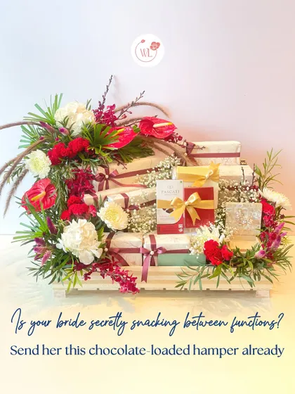 Is your bride secretly snacking between functions? This chocolate-loaded hamper, beautifully arranged with red and white florals in a slatted wooden tray, is the perfect delicious escape.