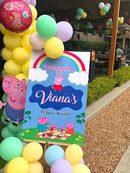 Welcome guests to the party with a personalized Peppa Pig themed sign. This entrance decor, complete with pastel balloons, sets a fun and inviting tone from the very beginning.