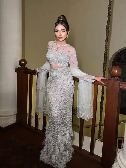 Presenting Viraaya. A stunning silver-grey gown with a feathered hem and bell sleeves.