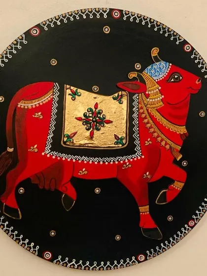 A duplicate image of the magnificent red cow plate, focusing on the intricate border and gold leaf detailing.