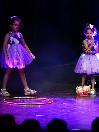 A playful moment from another kids' performance, using a hula hoop as a prop to add fun and creativity.