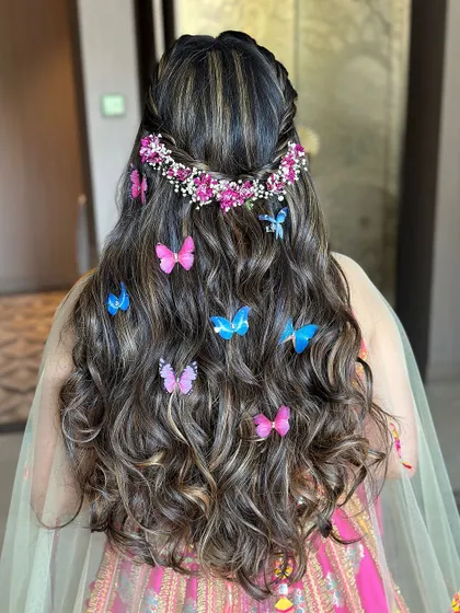 A detailed view of the butterfly and floral hair accessories, a look I love teaching for mehendi or carnival events.
