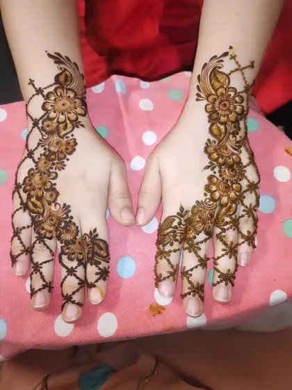 This pretty design features a floral vine combined with a net pattern across the fingers.