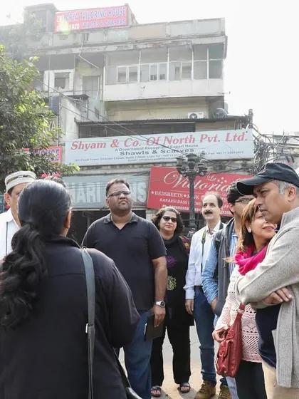 A group on a walk in Nai Sadak, discussing its transformation from a site of public spectacle and gambling to a bustling book market.