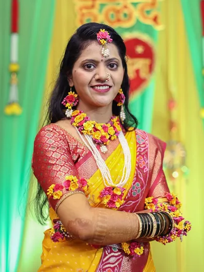 The bride posing with her arms crossed, smiling during her Haldi function.