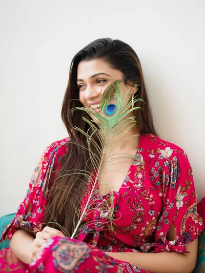 A playful, smiling version of the peacock feather portrait. This shot feels joyful and spontaneous.