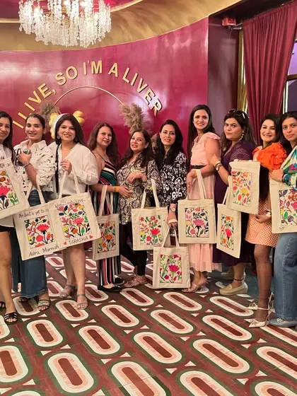 A group of ladies proudly showing off their hand-painted tote bags after a fun and creative workshop. A perfect activity for a memorable ladies' day out.