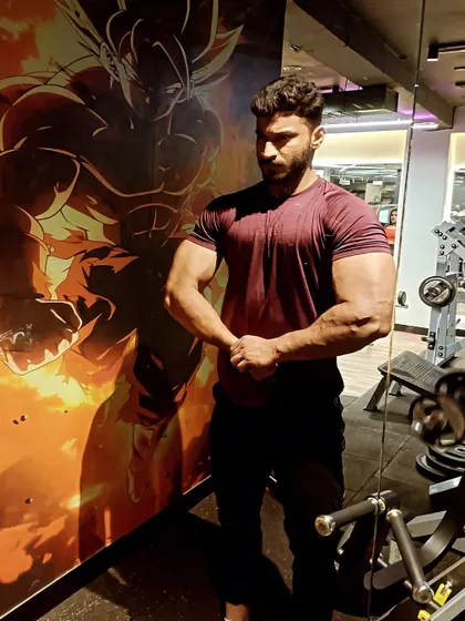 A most muscular pose in front of a Dragon Ball Z mural.