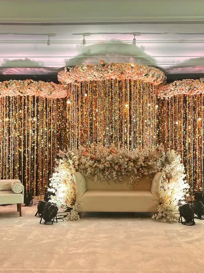 To create a truly showstopping reception, I designed this stage with clouds of baby's breath and a cascading curtain of glittering crystals. The lighting and floral arrangements work together to produce an ethereal and unforgettable backdrop for the couple.