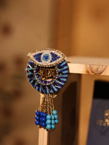 A handcrafted evil-eye tassel with 'Shubh' written in Hindi, a unique decorative piece from one of my Diwali hampers.