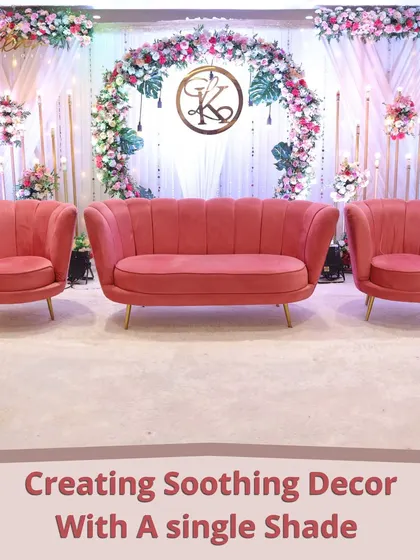 Creating a soothing and elegant look with a single shade. This reception stage features blush pink seating against a floral arch and monogram, showing the power of monochromatic design.