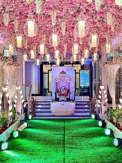 A pretty entrance decor with a ceiling of pink cherry blossoms and hanging lanterns. This design is ideal for creating a classy and romantic atmosphere for night functions like a reception or Sangeet.