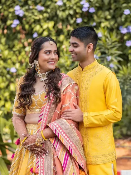 A close-up of the bride and groom during the Haldi ceremony. Her makeup is soft and natural, perfect for this intimate and colorful event.