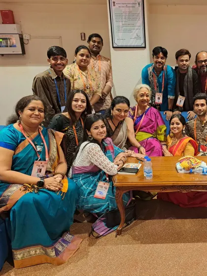 A beautiful, impromptu moment in the lobby of a festival, surrounded by artists of all ages, including the venerable Smt. Sudharani Raghupathy.