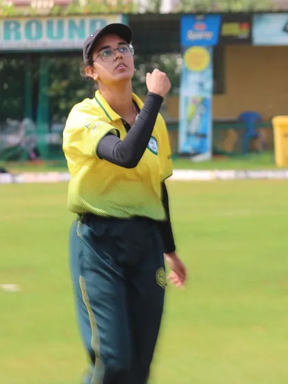 A fielder watches the ball's trajectory, ready to react, showcasing alertness on the field.