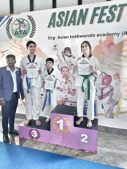 The team celebrating their victory on the podium with their coach at the Asian Fest.