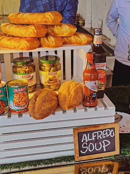 This setup is for our Alfredo Soup, served with a variety of breads like baguettes. The display includes accompaniments like baked beans and olives, offering a hearty and complete soup course.