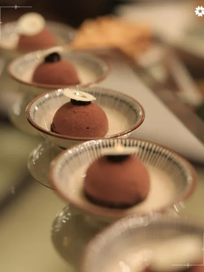 Individual chocolate mousse desserts, elegantly lined up for service. We bring the finesse of restaurant quality desserts to your home, ensuring a sweet and sophisticated end to your meal.