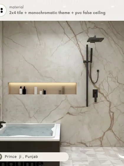 A monochromatic themed bathroom for Prince in Punjab, featuring a bathtub set against a full wall of marble-finish tile and sleek black fixtures for a bold, luxurious statement.