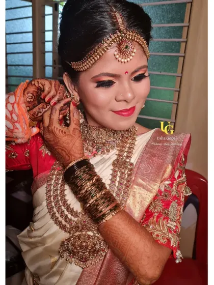 A candid moment as Shruthi puts on her earrings. The makeup is designed to look perfect from every angle.