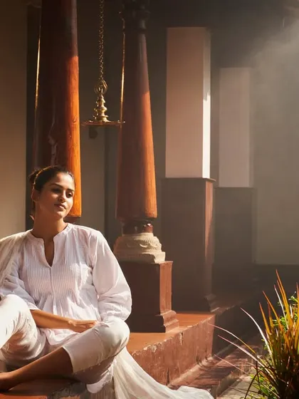 A guest enjoying a moment of post-treatment bliss. After an invigorating Ayurvedic therapy, the serene environment of our wellness center helps deepen the feeling of relaxation and rejuvenation.